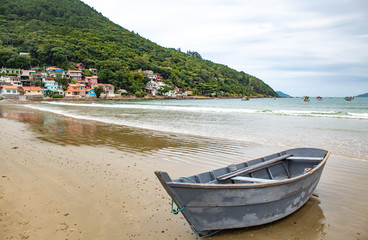 Fototapeta na wymiar Florianopolis Reflexo da montanha na areia e um barco de pescador ancorado na Praia do Pântano do Sul, Florianópolis - SC, Brasil