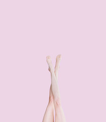 girl legs on a pink background raised up