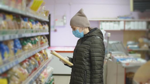 woman in protective mask chooses pasta