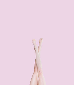 Girl Legs On A Pink Background Raised Up