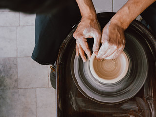 Work behind the potter's wheel Ceramist is bringing finishing touches to a new ceramic cup