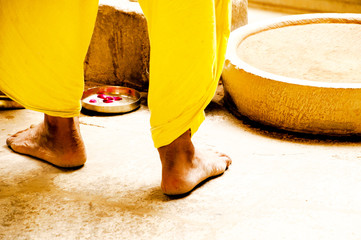 man with traditional rpa lights incenses in a temple in india, with very comfortable yellow slippers