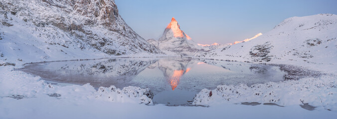 The Matterhorn top reflected in Riffelsee lake at sunrise, mountains covered with fresh white snow. Rotenboden, Zermatt, Switzerland