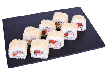 Traditional fresh japanese sushi rolls on a black stone Caesar Roll on a white background. Roll ingredients: chicken fillet, philadelphia, tomato, nori, rice, panko crackers.