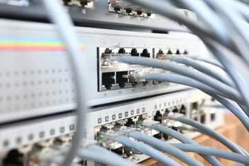 Close-up of network cables connected to framework. Internet switch station. Bunch of grey plugs. Telecommunication main distribution frame. Server and modern technology data center concept