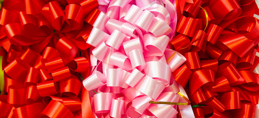 Curly red ribbon and pink background. Texture background. Patten background.
