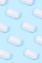 Disposable medical mask on blue background. Healthcare and medical concept.