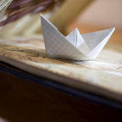 Paper checkered boat on a book.