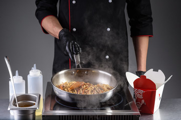 the process of cooking noodles with meat and vegetables in the restaurant kitchen31