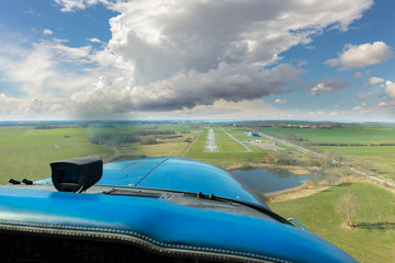 A landing approach in a cloudy sky to the small airport on the German island of Rügen in the...