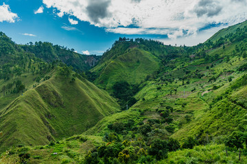 Amazing green Lake toba tall slopes with Sipiso Piso waterfall far away
