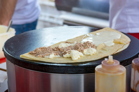 Cheff preparing tasty pancake with wallnuts and cream.