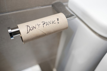 empty toilet roll with Don't panic message written on it - Corona virus concept