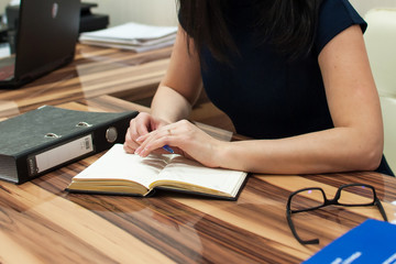 the girl is sitting at the table and working. Office work. Self-education