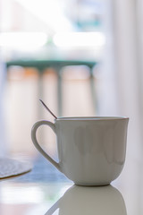 Cup with spoon on white table