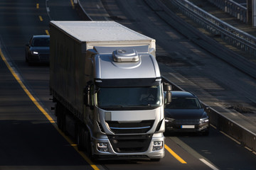 a modern grey truck driving on an highway