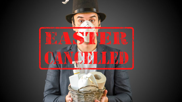 Easter holidays cancelled amid coronavirus covid-19 respiratory disease quarantine, lockdown in Europe. Conceptual photo of a man with rabbit ears and gift basket with toilet paper, sanitizer, mask.