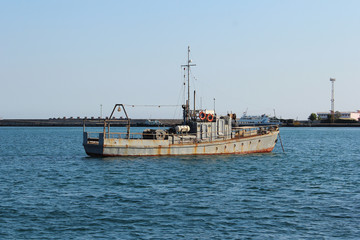 Old rusty boat in city port