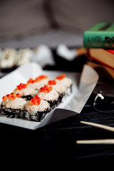 Sushi, Asian food, rolls, Philadelphia, sesame. Restaurant food. Fast food. With books, study, glasses for sight.