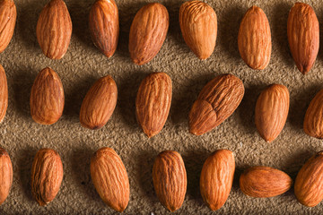 Almonds on a beige textured concrete background. Place for text. Aesthetic photography.