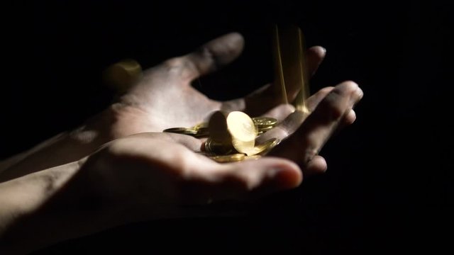 gold coins falling dirty hands of worker on black background. concept of jackpot lottery