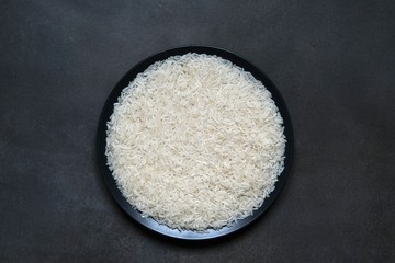 White rice in a plate on a dark background. Healthy diet.