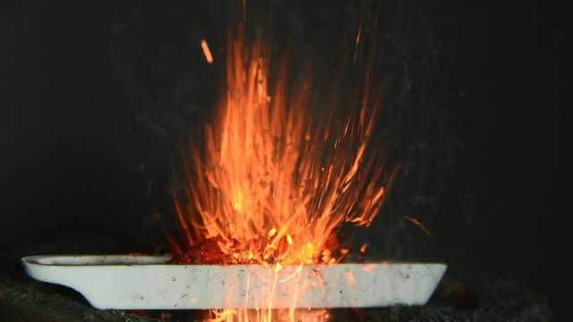 Ammonium dichromate burns in a tray with orange sparks, a green powder develops as a combustion product.