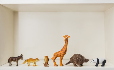 children's toys animals stand on a shelf a giraffe, panda, donkey, fox and owl