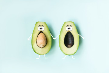 2 halves of avocado lie on the background of a funny face cartoon look, funny look of vegetables