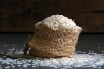 White rice in a bag made of coarse natural fabric.