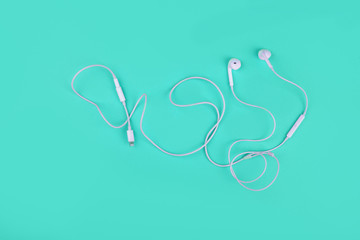 Headphones for the phone lie on a bright blue background.