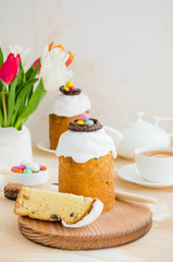 Obraz na płótnie Canvas Easter composition. Easter Cake - Russian and Ukrainian Traditional Kulich with easter eggs on a light stone background. Paska Easter Bread. Selective focus. Vertical orientation. Copy space