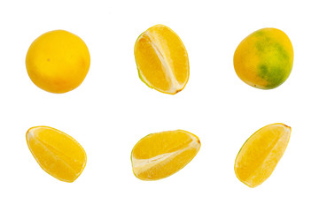 two whole yellow-green grapefruits and four quarters on a white background. Isolate