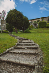 View towards the entrance of beautiful gardens at Stanjel, slovenia on a picturesque rainy spring day with green grass and other foliage. Visible stairs made of stones