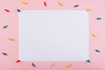 white sheet fastened with clerical multi-colored buttons on a pink background. Multicolored...