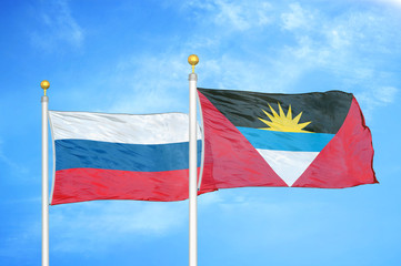 Russia and Antigua and Barbuda  two flags on flagpoles and blue cloudy sky