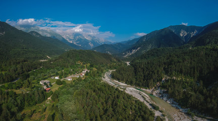 Fototapeta na wymiar Aerial panorama of Resia valley looking towards the village of Stolvizza, torrente Resiaand Rio Lommig on a warm summer day in Italian Alps