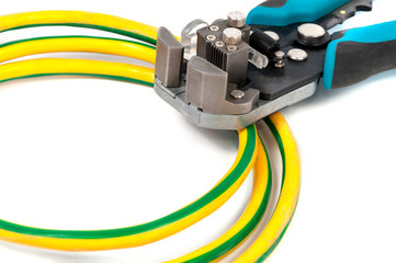 Green-yellow wire for earthing and automatic stripper, close-up on a white background