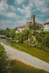 Fototapeta na wymiar Vertical photo of the town of Cividale del Friuli in Eastern italy on a picturesque sunny day. Picture taken on ponte del Diavolo above Nadige river