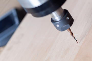 the spindle of the milling machine with the milling cutter is located above the wooden workpiece