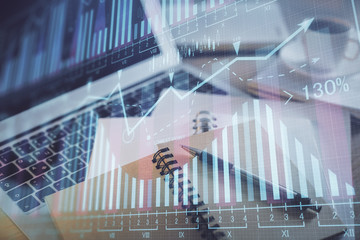 Double exposure of financial chart drawing and desktop with coffee and items on table background. Concept of forex market trading