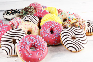 donuts in different glazes with chocolate, sprinkles and stripes