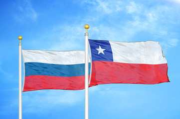 Russia and Chile two flags on flagpoles and blue cloudy sky