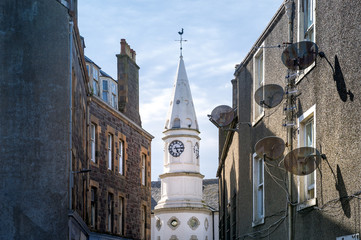 Streets of Campbeltown center, clock tower and city hall between new buildings. Kintyre peninsula, Scotland.
