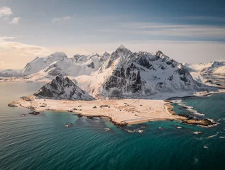Zelfklevend Fotobehang aerial drone panorama view over flakstad. Beautiful mountains in winter wonderland north of norway. Peaceful and ambient aerial video. sunny day behind arctic circle. Coastline full of beaches.  © Jiri