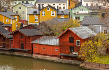 Obraz premium Porvoo town, Finland. Old red wooden houses on the river coast on a cloudy day