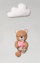 Baby crib mobile - kids toys, on light background.