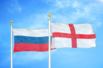 Russia and England two flags on flagpoles and blue cloudy sky