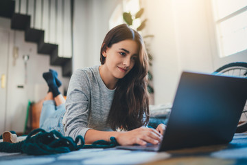 Remote Work, Attractive young woman translator working from home remotely lying in comfortable living room using modern laptop computer, Young girl having video call via laptop, Home Office Concept