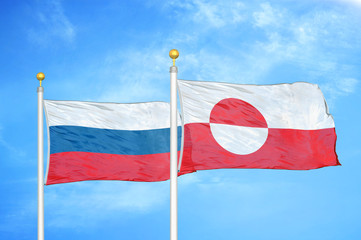 Russia and Greenland two flags on flagpoles and blue cloudy sky